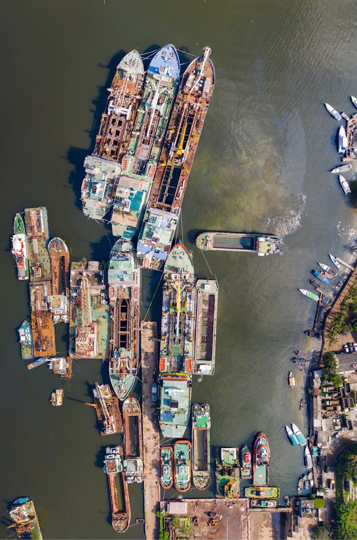 Aerial view of a bustling shipyard with multiple ships docked, showcasing industrial and maritime activity.
